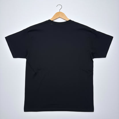 Black t-shirt on a wooden hanger against a white background