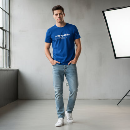 Man wearing a blue t-shirt with 'propaganda' text in a minimalistic room.