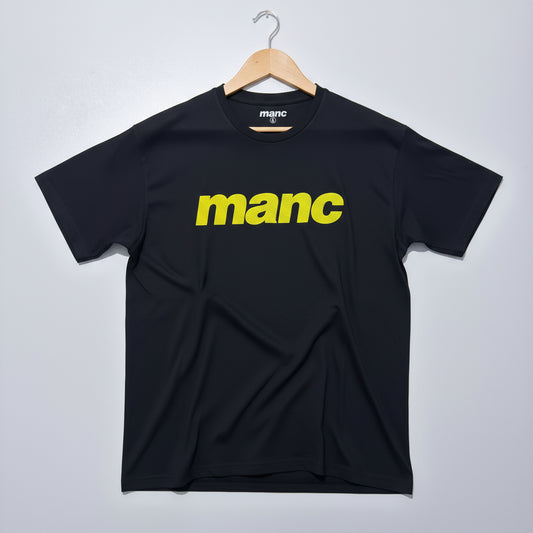 black t-shirt with the word 'manc' written on it in a yellow puff vinyl against a white backdrop