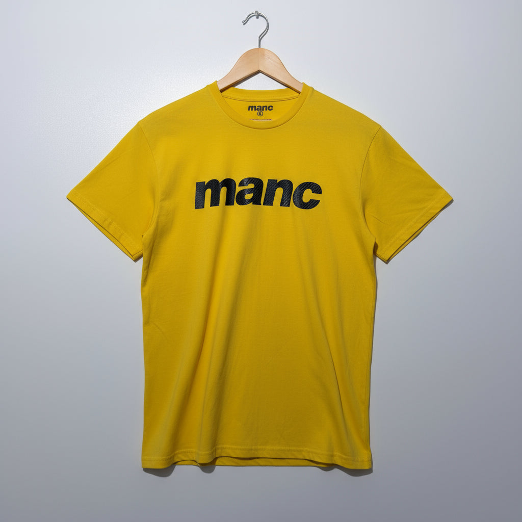 Yellow manc t-shirt on a hanger against a grey background