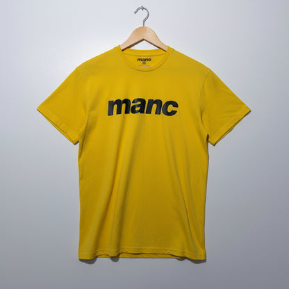 Yellow manc t-shirt on a hanger against a grey background