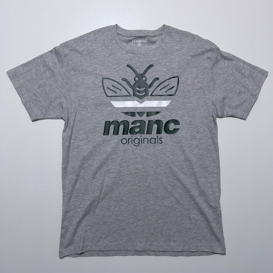 Grey t-shirt with a manc originals logo and text on a light grey background