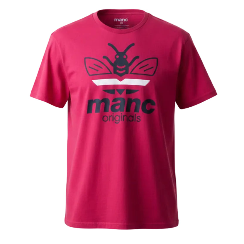 Red t-shirt with a 'manc originals' logo on a wooden rack and table against a white wall