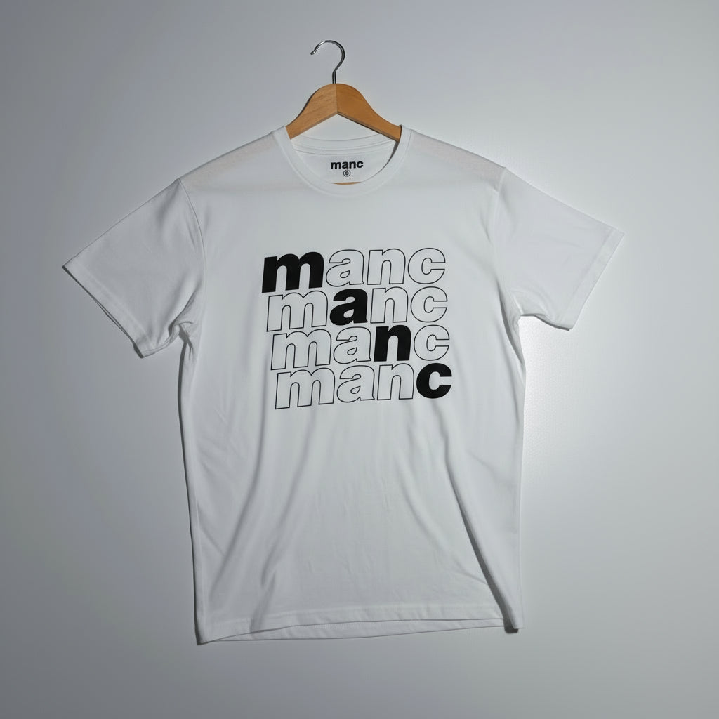 White t-shirt with 'manc' text design on a hanger against a grey background