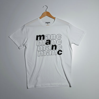 White t-shirt with 'manc' text design on a hanger against a grey background